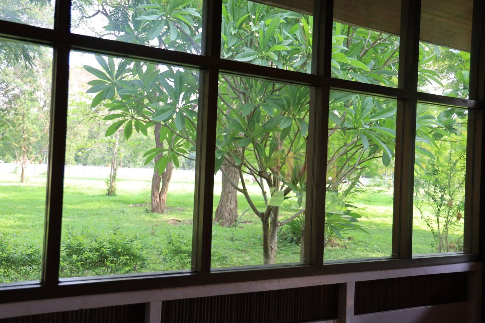 View from a teak-framed window onto the gardens of the Meiktila Hotel