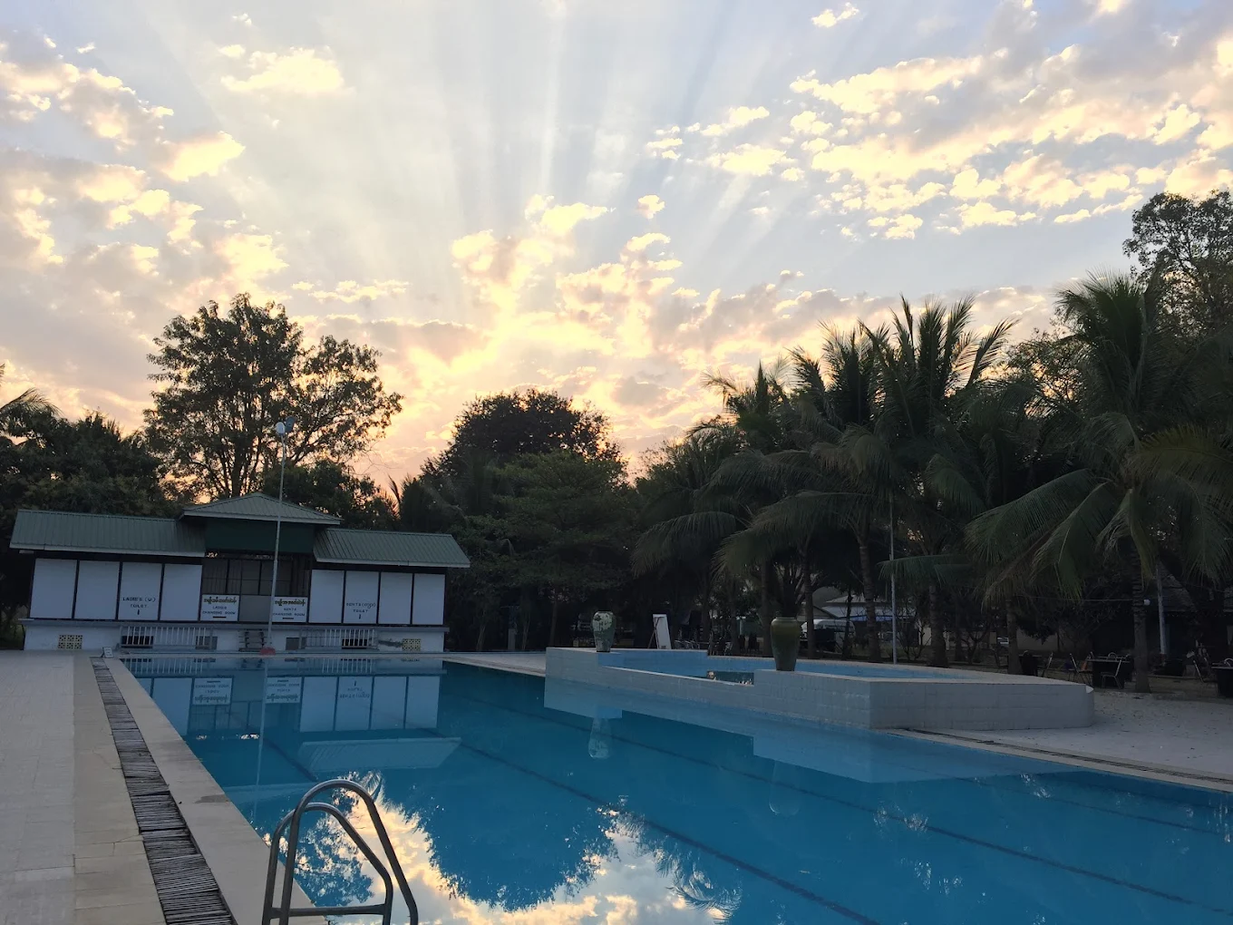Outdoor pool at sunset framed by palms at the 38-acre Meiktila Hotel